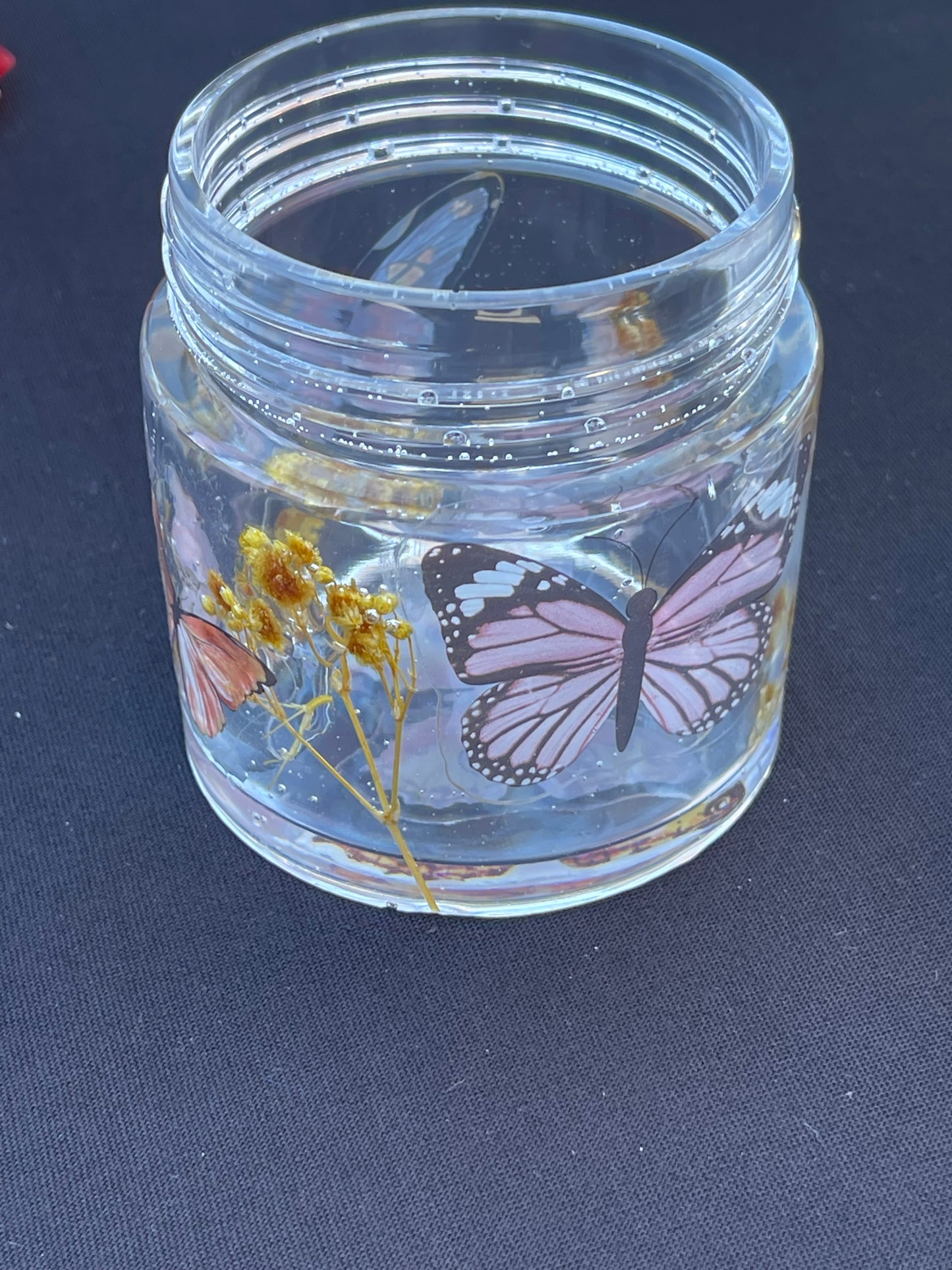 Cylinder jars with lids that screw on various designs and colors