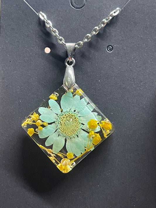 Teal daisy with baby’s breath preserved in resin on an 18” chain